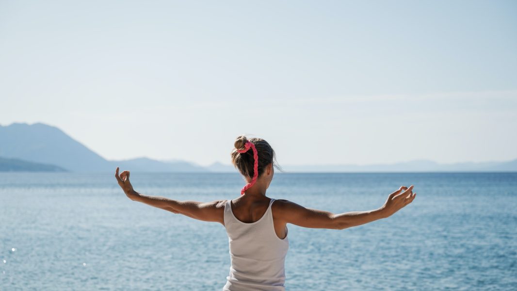 Young woman morning meditation by the sea